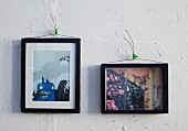 Black-framed pictures hung on wall using wire