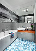 Grey walls and black and white photo mural reflected in mirror; monochrome colour scheme in bathroom combined with Oriental, blue tiled floor