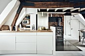 Compact kitchen in open-plan attic interior in historical building
