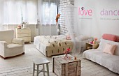 Rustic, shabby-chic bedroom with wooden crate, stool, double bed with canopy and comfortable armchair on pale board floor
