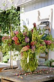 Luxuriant bouquet of lupins in glass vase on rustic wooden table