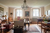Period furniture, chandelier and arched windows in spacious living room