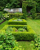 Quadratische Rabatte mit niedriger Hecke in sommerlichem Garten