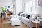 Offener Wohnraum mit hellem Sofa und Blick in den Essbereich