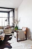 Leather armchair with wooden frame on white wooden floor, and retro standard lamp in front of window