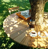 Selbstgebauter Gartentisch aus Lärchenholz, rund um einen Baumstamm