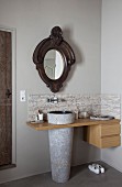 Waschtisch mit konischem Standwaschbecken in Holzplatte und Schubladenelement, oberhalb antiker Spiegel an Wand, in Badezimmerecke