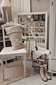 Hessian sack on white-painted kitchen chair, vintage ladies' laced boots and vintage-style flea-market finds on white-painted wooden floor
