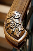 Wooden handrail with carved floral motif