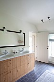 Twin washstand with wooden base unit and marble counter in rustic bathroom