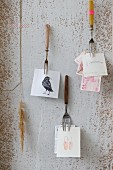 Various vintage forks nailed to wall used as holders for notes