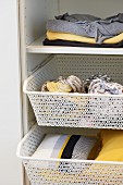 Pretty wire baskets used as tidy storage solution in wardrobe