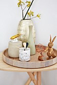 Stillleben mit Vasen, Holzhasen und vergoldetem Porzellankäfer auf massivem Holztablett und Holztisch