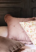 Various pillows in pink, brown and floral pattern