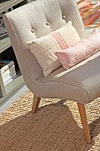 Fifties-style, ecru easy chair and scatter cushions on sisal rug
