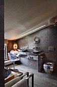 Extravagantes Designerbad unter dem Dach, transparenter Schalenstuhl vor Waschtisch mit zwei verchromten Schüsseln auf massivem Tisch, an Wand Natursteinfliesen in Grau