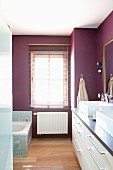 Elegantes Bad mit weißem Waschbeckenunterschrank und violetter Wänden