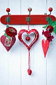 Red and white spotted heart ornament decorated with zinnia, dahlia and snap dragon hung on vintage coat rack