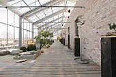 Converted greenhouse with wooden decking and exposed brick wall
