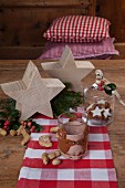 Hand-crafted felt glass sleeve next to wooden stars on festively decorated wooden table