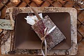 Birch bark place mat with name card, cutlery and birch bark serviette holder on ceramic dish