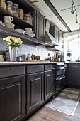 Kitchen counter with dark base and wall units in country-house kitchen