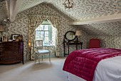 English-style attic bedroom with floral wallpaper on walls and ceiling and matching curtains