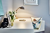 White desk lit by retro table lamp and chair with cushion