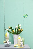 Pastel Easter arrangement; tulips in ceramic beaker, eggs and rabbit ornaments