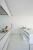 Island counter in open-plan white kitchen