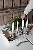 Four white candles in DIY candelabra made from half a birch log and glass drip catchers