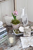 Romantische Landhausdeko zu Ostern mit Hyazinthe und Kerzen auf altem Holztisch
