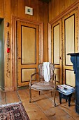 Rococo-style chairs in corner in front of fitted cupboards with painted doors