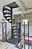 Hand-crafted, black vintage spiral staircase in rustic country house