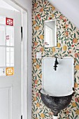 Vintage sink on wallpapered wall