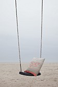 Cushion with crocheted seagull motif on swing on beach