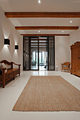 Heller Wohnraum mit Sisalteppich und traditionellen Holzmöbeln