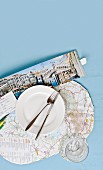 Place setting on place mat made from map and open Venice travel brochure