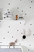 Wandansicht mit schwarz-weißer Sternentapete, Vintage-Wandkonsole und zwei Köfferchen mit Sternenmotiv