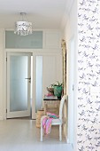 Open frosted glass door, Baroque chair and lace-patterned ceiling lamp in foyer