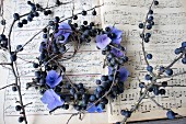 Wreath of hydrangea flowers and sloe branches on old sheet music