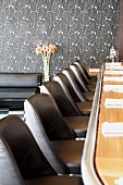 Bar counter with black leather stools in restaurant