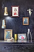 Black-painted chipboard panels on walls and kitchen cupboards, religious icons and pendant lampa