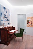 Upholstered chair at antique writing desk below painting on wall in modern interior