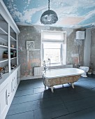 Free-standing vintage bathtub in large bathroom with shelving and patinated walls and ceiiling