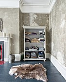 Clothes on open-fronted shelves in niche with patinated walls