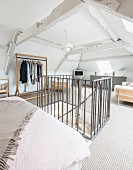 Bedroom in converted attic with head of stairs in foreground