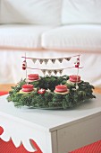 Advent wreath decorated with Father Christmas figurines and lettering on bunting with festive greeting in German
