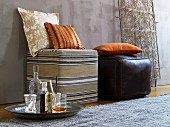 Cushions on pouffes covered in African fabric and leather and ornate metal lattice in background