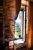 French window with view of mountain landscape in stone wall